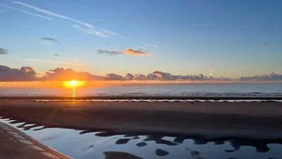 a sunset on the beach with a reflection in the water at Double Room with Private Bathroom 16 Havelock Street - 6 in Blackpool