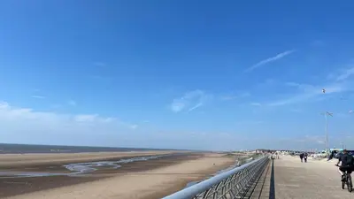 a beach with people riding bikes on a bridge at Double Room with Private Bathroom 16 Havelock Street - 6 in Blackpool