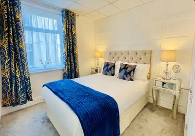 a bedroom with a bed with a blue blanket on it at Double Room with Private Bathroom 16 Havelock Street - 6 in Blackpool
