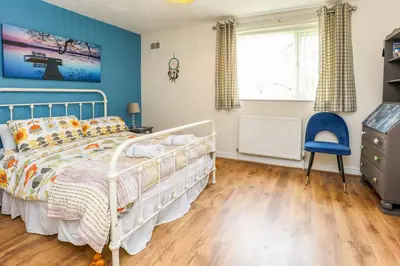 a bedroom with a white bed and a blue wall at Carlton Villa - Gorgeous detached home with parking in Liverpool