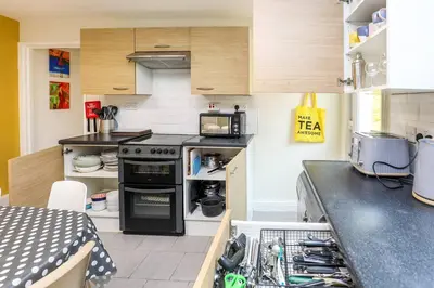 a small kitchen with a stove and a microwave at Carlton Villa - Gorgeous detached home with parking in Liverpool