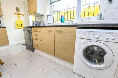 a kitchen with a washing machine and a sink at Carlton Villa - Gorgeous detached home with parking in Liverpool