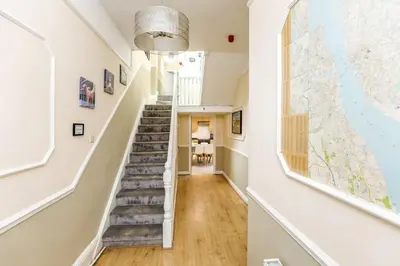 a hallway with stairs in a home with a large window at Carlton Villa - Gorgeous detached home with parking in Liverpool