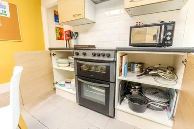a kitchen with a stove and a microwave at Carlton Villa - Gorgeous detached home with parking in Liverpool