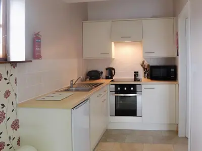 a kitchen with white cabinets and a sink at Valley View - 29530 in Scotforth