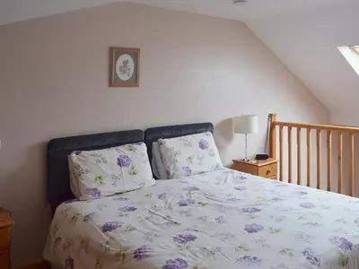 a bedroom with a bed with purple flowers at Valley View - 29530 in Scotforth