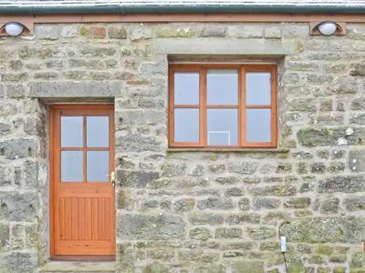 a brick building with two windows and a wooden door at Clougha View - 29531 in Scotforth