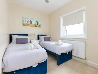 two beds in a small room with a window at Mulberry House in Lytham St Annes