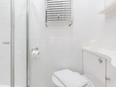 a white bathroom with a shower and a toilet at Mulberry House in Lytham St Annes