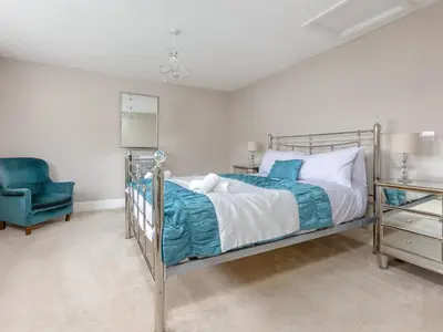 a bedroom with a bed and a blue chair at Mulberry House in Lytham St Annes