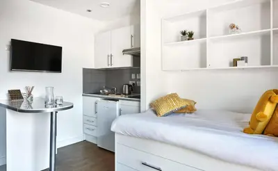 a small kitchen with white cabinets and a table at Liverpool Georgian Quarter in Liverpool