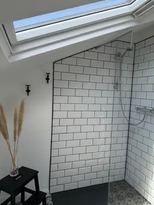 a bathroom with a shower with a skylight at The Eaves - Victorian second floor, open plan apartment in Southport