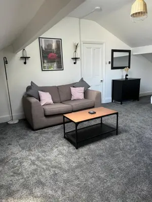 a living room with a couch and a coffee table at The Eaves - Victorian second floor, open plan apartment in Southport