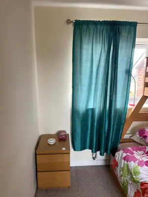 a bedroom with a bed and a green curtain at Wavertree Accomodation in Liverpool
