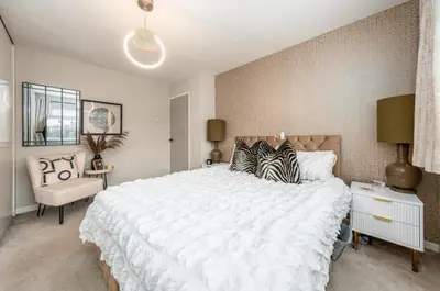 a bedroom with a large white bed and a chair at Everythings Rosey at Rosecroft in Ormskirk