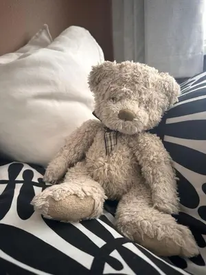 a brown teddy bear sitting on a bed at Everythings Rosey at Rosecroft in Ormskirk