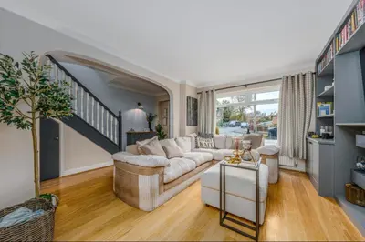 a living room with a couch and a staircase at Everythings Rosey at Rosecroft in Ormskirk