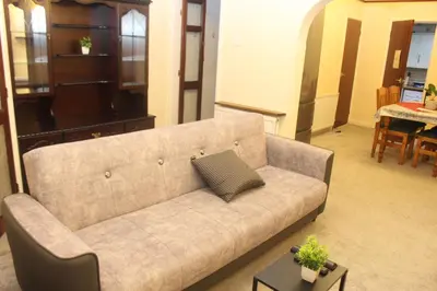 a living room with a couch with a pillow on it at mater dei suite near royal liverpool hospital in Liverpool