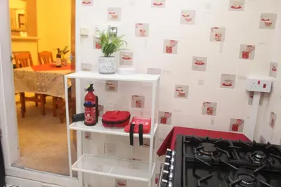a kitchen with a stove and a white tiled wall at mater dei suite near royal liverpool hospital in Liverpool