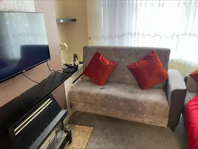 a living room with a couch with two red pillows at mater dei suite near royal liverpool hospital in Liverpool