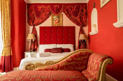 a red bedroom with a bed and a couch at Hotel Rouge in Blackpool