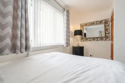 a bedroom with a white bed and a window at Homestay in Knowsley