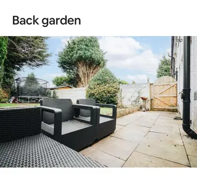 a black garden bench sitting on a sidewalk at Homestay in Knowsley