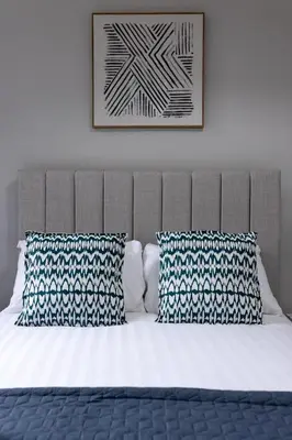 a bed with two pillows and a picture on the wall at Cowley House - Air Host & Stay - Sleeps 7 in Liverpool