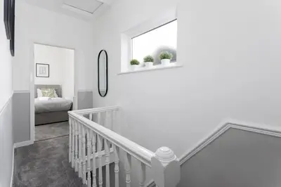 a white staircase in a white room with a window at Cowley House - Air Host & Stay - Sleeps 7 in Liverpool