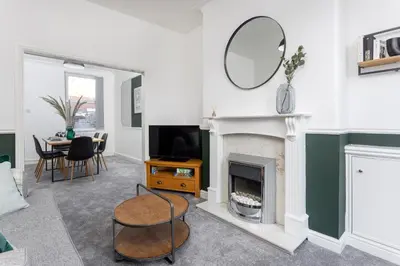 a living room with a fireplace and a mirror at Cowley House - Air Host & Stay - Sleeps 7 in Liverpool