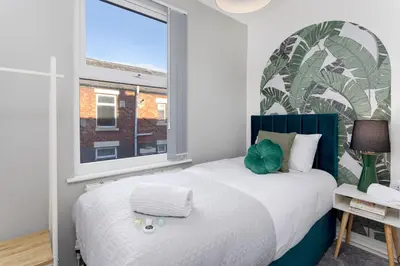 a bedroom with a bed with a large window at Cowley House - Air Host & Stay - Sleeps 7 in Liverpool