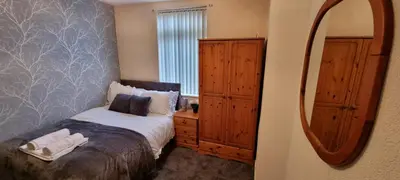 a bedroom with a bed and a dresser and a mirror at A cozy home in Liverpool in Liverpool
