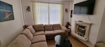 a living room with a couch and a fireplace at A cozy home in Liverpool in Liverpool