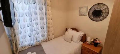 a small bedroom with a bed and a fan at A cozy home in Liverpool in Liverpool