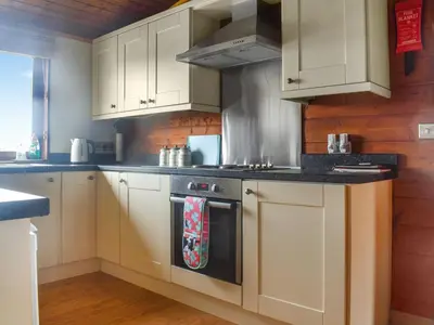a kitchen with white cabinets and a stove at Chestnut Lodge in Pilling