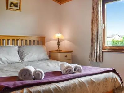 a bedroom with a bed with towels on it at Chestnut Lodge in Pilling