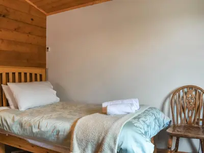 a bedroom with a bed and a chair at Chestnut Lodge in Pilling