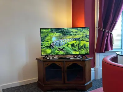 a flat screen tv sitting on top of a wooden stand at Circus Suite Blackpool in Blackpool