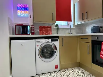 a kitchen with a washing machine in a kitchen at Circus Suite Blackpool in Blackpool