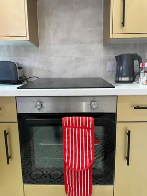 a red oven mitten hanging from the door of a stove at Circus Suite Blackpool in Blackpool