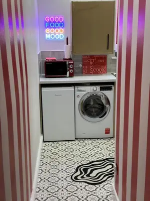 a laundry room with a washing machine and a sign at Circus Suite Blackpool in Blackpool