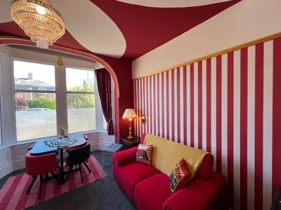 a living room with a red and white striped wall at Circus Suite Blackpool in Blackpool