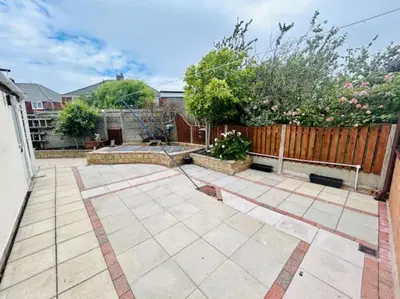 a garden with a patio and a fence at Fairholmes House in Thornton