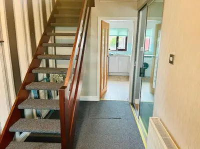 a staircase in a house with a hallway and a door at Fairholmes House in Thornton