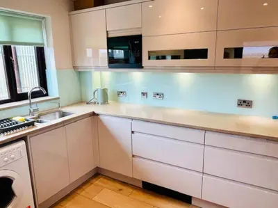 a white kitchen with a sink and a dishwasher at Fairholmes House in Thornton