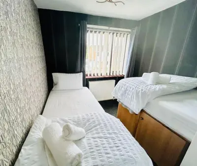 a small room with two beds with towels on them at Fairholmes House in Thornton
