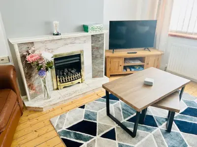 a living room with a fireplace and a table at Fairholmes House in Thornton