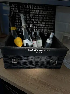 a black basket filled with bottles of wine on a table at No1,luxury 1 bed apartment in Saint Annes on the Sea