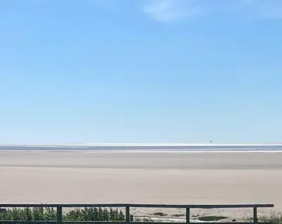 a view of a beach with a fence and the ocean at Beachside Lodge - Sleeps 6 - Pets ok - Parking in Morecambe