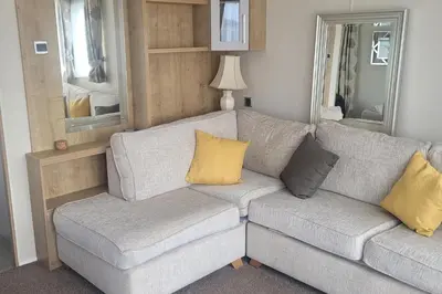 a gray couch with yellow pillows in a living room at Beachside Lodge - Sleeps 6 - Pets ok - Parking in Morecambe